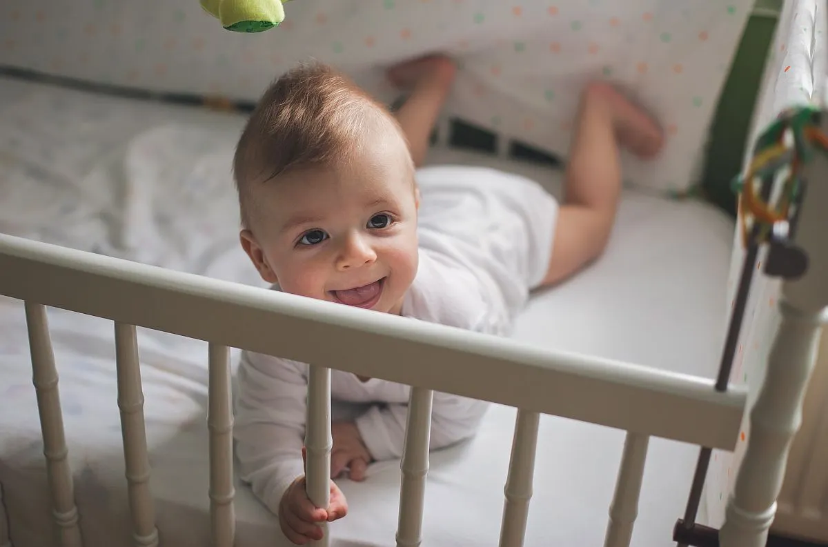 Niemowlę leżące w łóżeczku dziecięcym Niemowlę leżące w łóżeczku dziecięcym